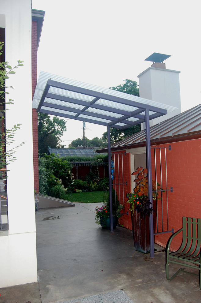 Ispirazione per un patio o portico eclettico dietro casa e di medie dimensioni con lastre di cemento