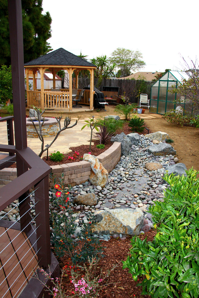 Large trendy backyard stone patio photo in San Diego with a fire pit and a gazebo