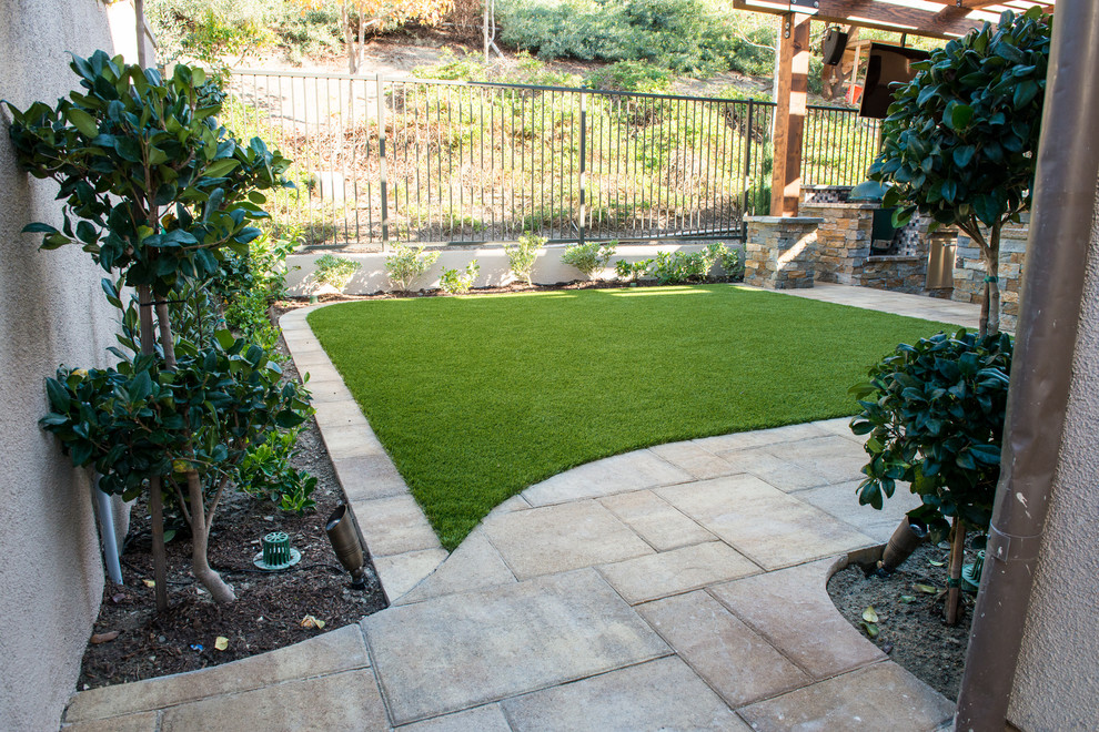 Imagen de patio clásico renovado de tamaño medio en patio trasero con cocina exterior, adoquines de piedra natural y pérgola