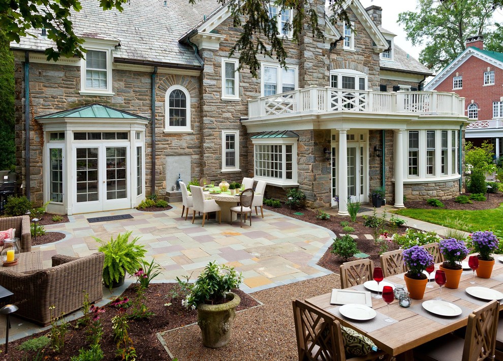 Exemple d'une terrasse arrière chic de taille moyenne avec un foyer extérieur, des pavés en pierre naturelle et aucune couverture.