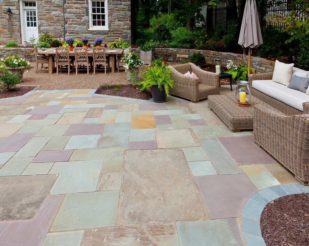 Example of a mid-sized classic backyard stone patio design in Other with a fire pit and no cover