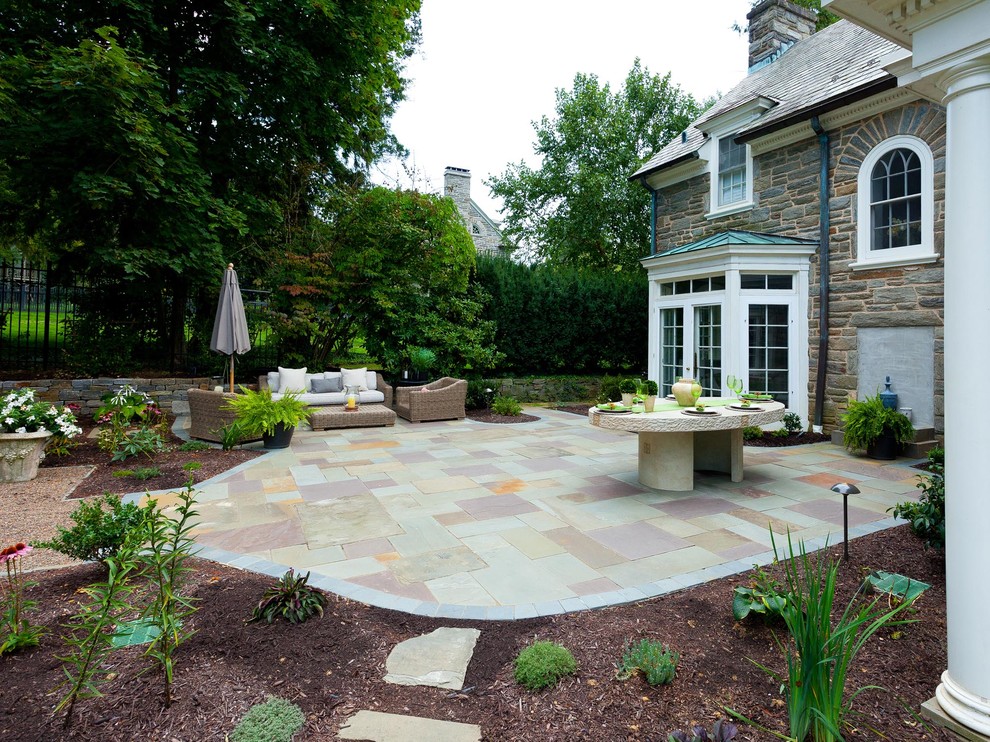 Patio - mid-sized traditional backyard stone patio idea in Other with a fire pit and no cover