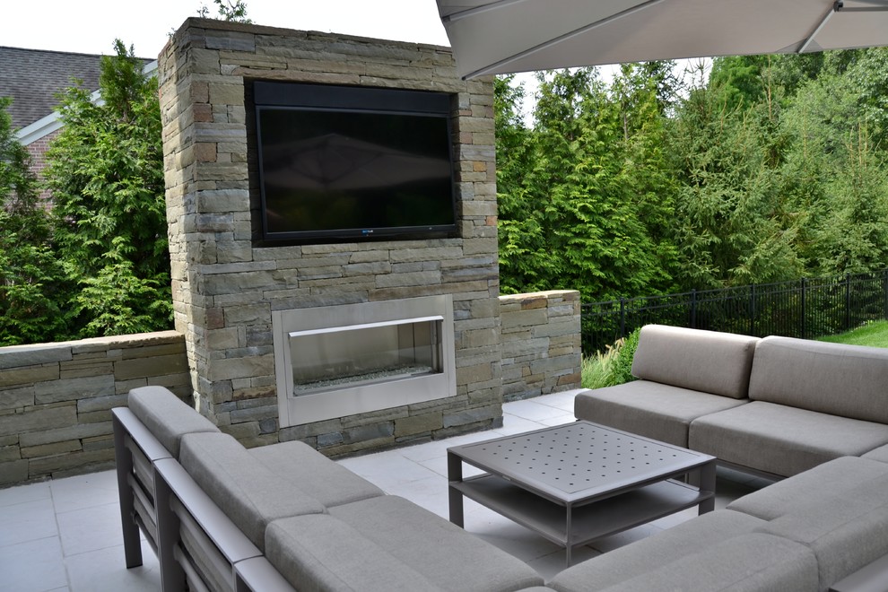 Inspiration pour une terrasse arrière minimaliste de taille moyenne avec un foyer extérieur.