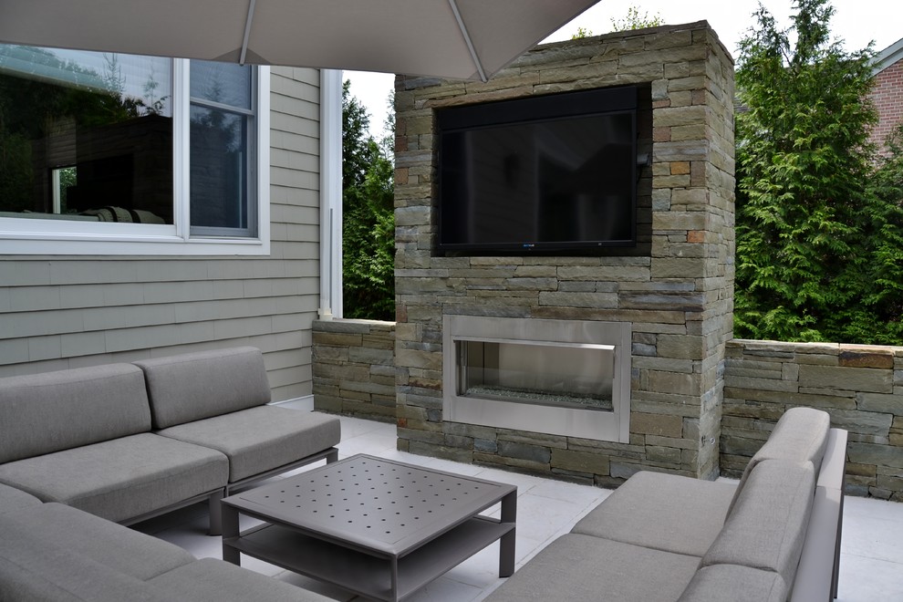 Photo of a medium sized modern back patio in New York with a fire feature.