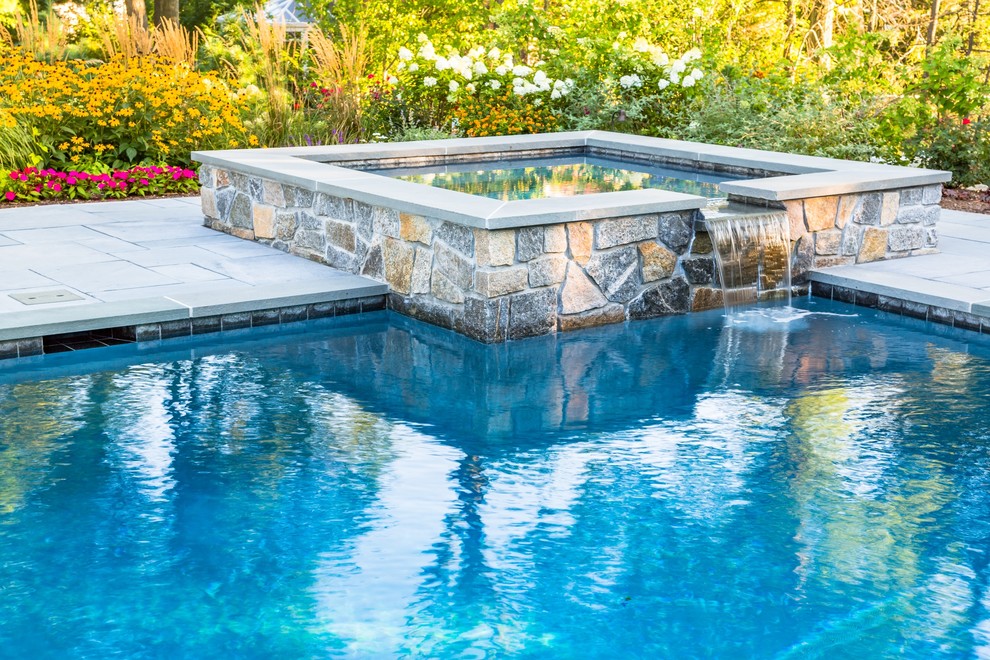 Inspiration for a large timeless backyard stone pool remodel in New York