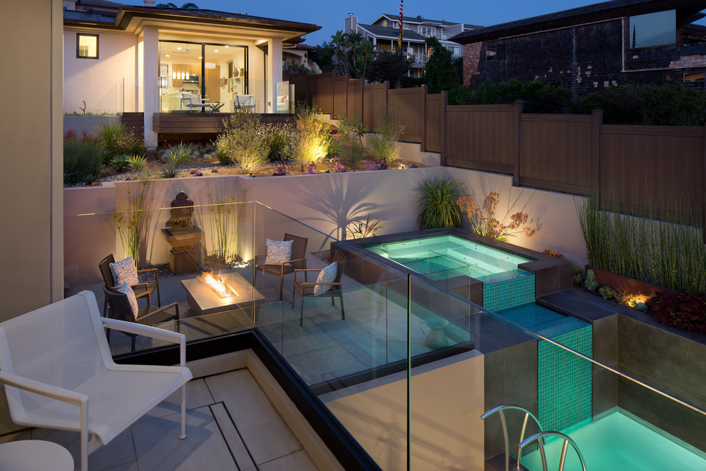 Modelo de patio minimalista grande sin cubierta en patio trasero con brasero y losas de hormigón