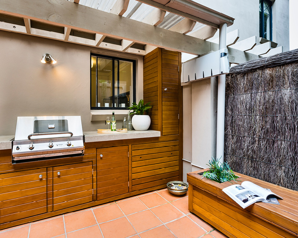 Small eclectic courtyard patio in Sydney with an outdoor kitchen.