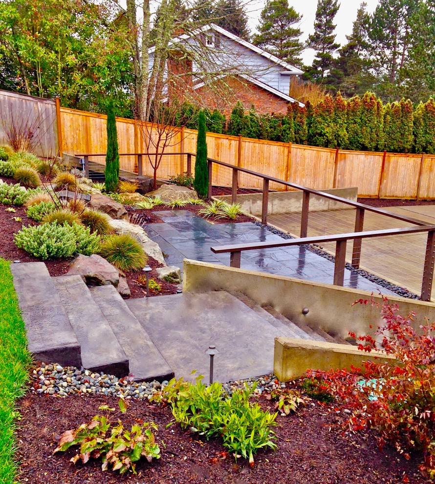 Large minimalist backyard stone patio photo in Seattle with no cover