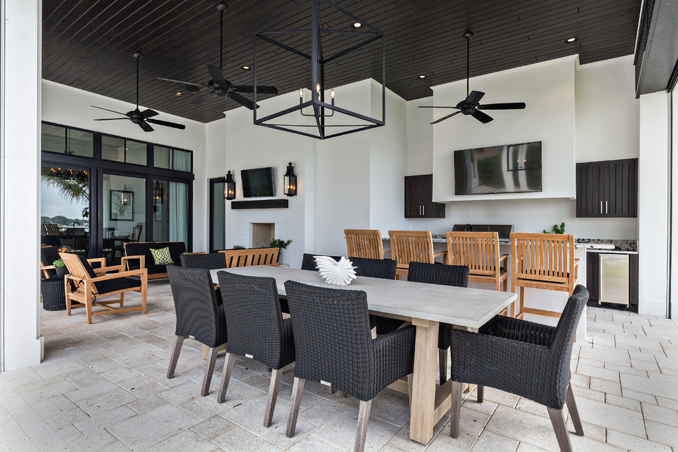 Large contemporary back patio in Miami with an outdoor kitchen, concrete paving and a roof extension.
