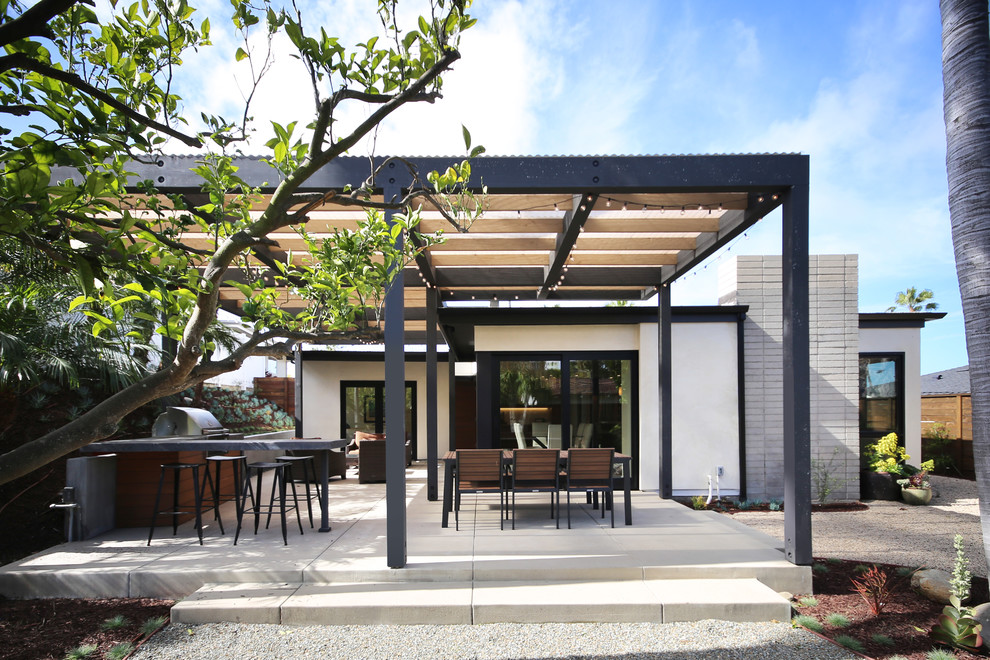 Example of a minimalist backyard concrete patio design in Orange County with a pergola