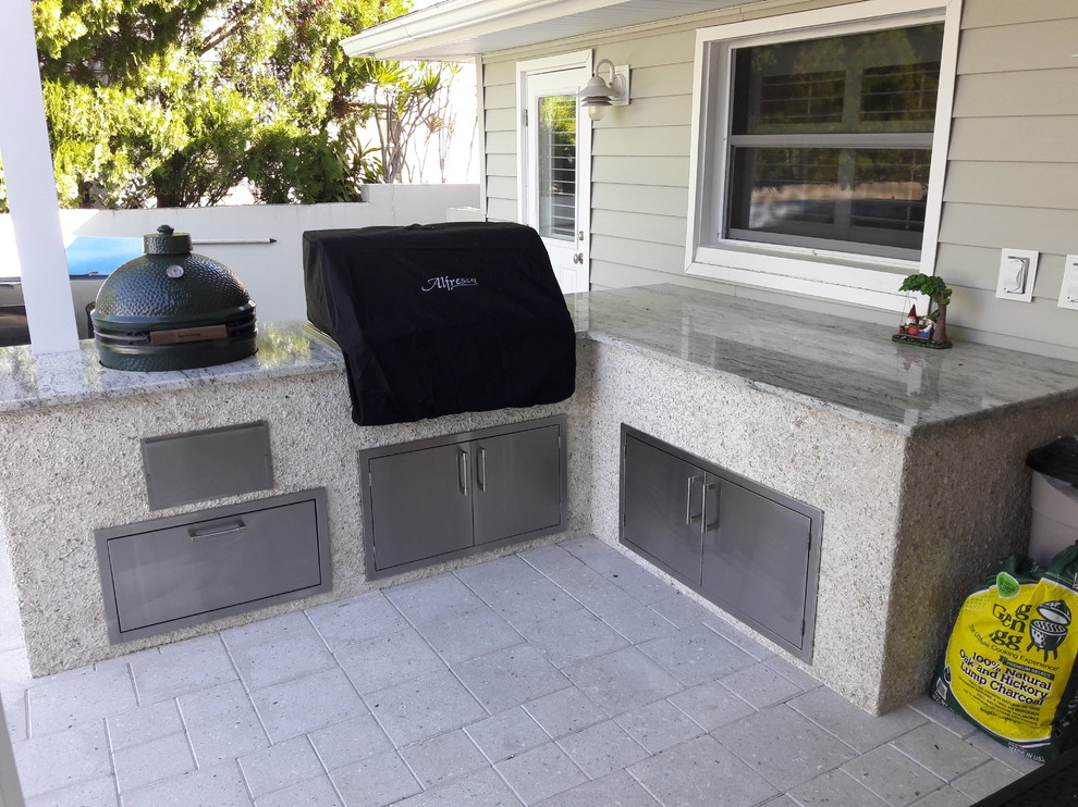 Example of a large trendy backyard concrete paver patio kitchen design in Tampa with a roof extension