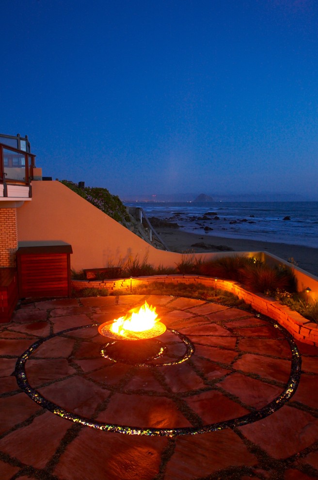 Aménagement d'une terrasse bord de mer avec un foyer extérieur.