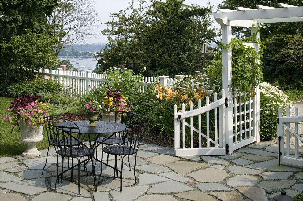 На фото: двор в морском стиле с покрытием из каменной брусчатки и забором без защиты от солнца