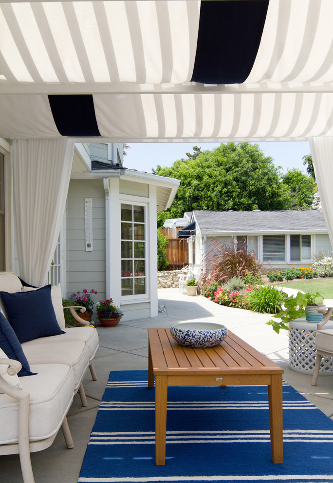 Patio - large coastal backyard stamped concrete patio idea in Los Angeles with a pergola
