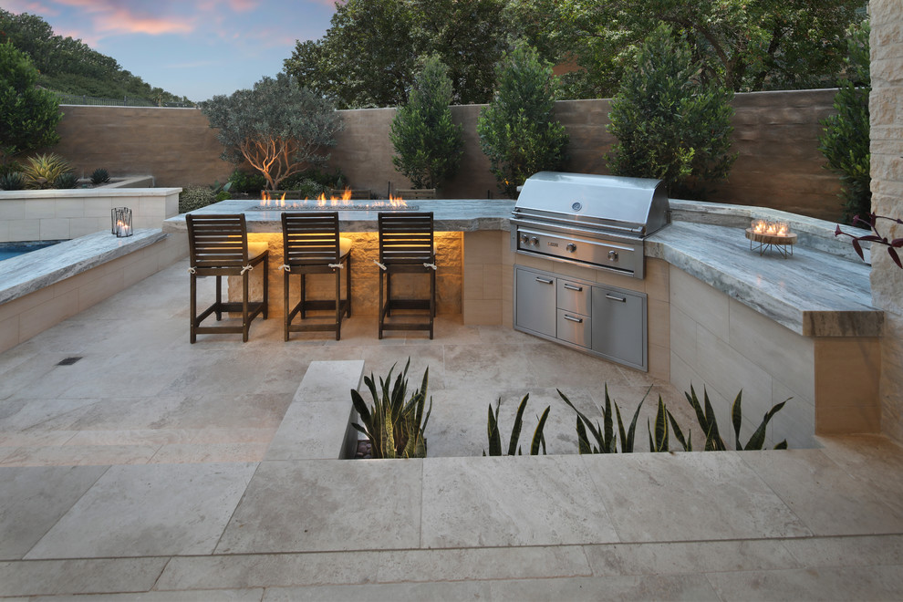 Example of a transitional backyard stone patio design in Orange County with a gazebo
