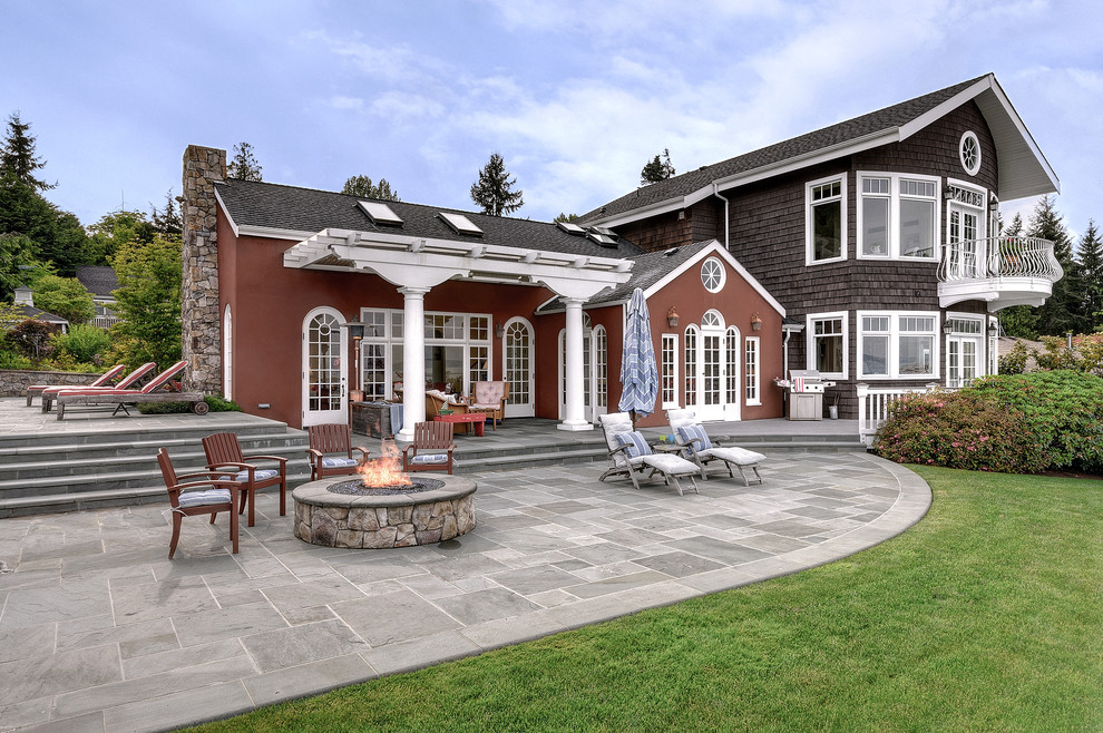 Foto di un grande patio o portico costiero dietro casa con un focolare, una pergola e pavimentazioni in pietra naturale