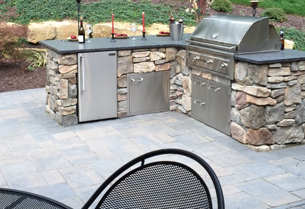 Example of a large classic backyard concrete paver patio design in Other with no cover and a fire pit