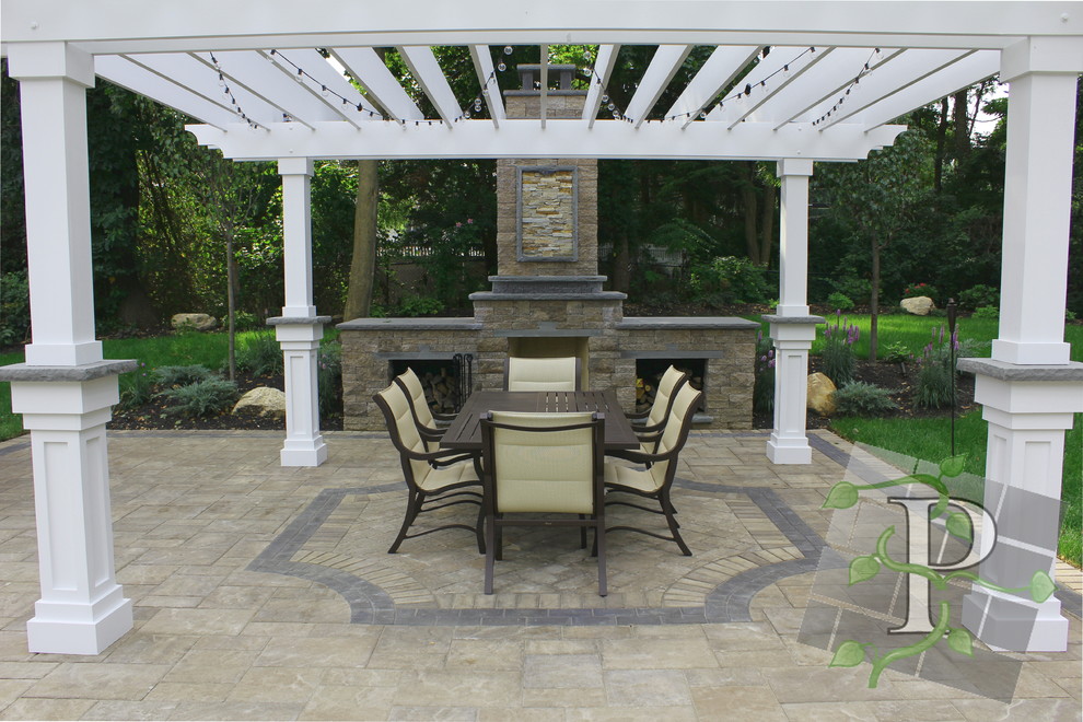 Diseño de patio clásico grande en patio trasero con cenador y adoquines de hormigón