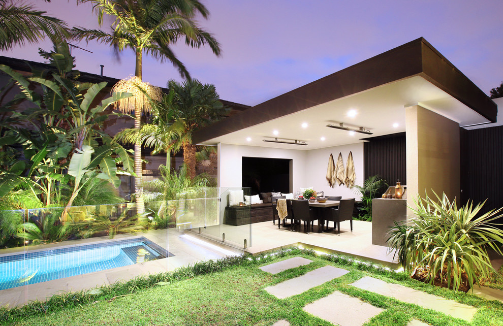 Idee per un patio o portico tropicale dietro casa con pavimentazioni in cemento e un gazebo o capanno