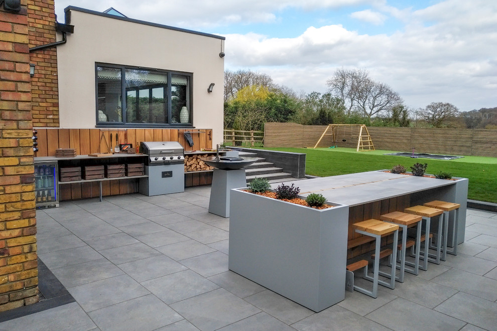 This is an example of a medium sized contemporary back patio in Other with an outdoor kitchen, tiled flooring and no cover.