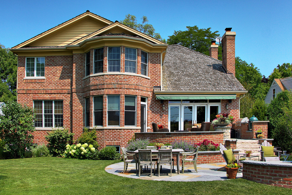 На фото: двор на заднем дворе в классическом стиле с покрытием из каменной брусчатки и летней кухней с