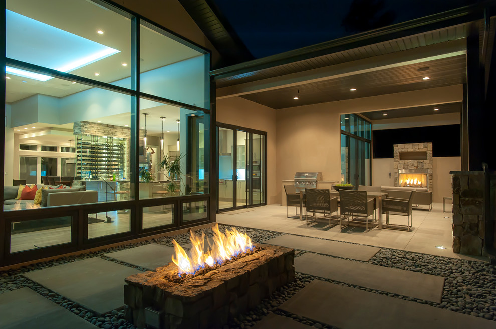 Inspiration for a medium sized contemporary back patio in Denver with a fire feature, concrete slabs and a roof extension.