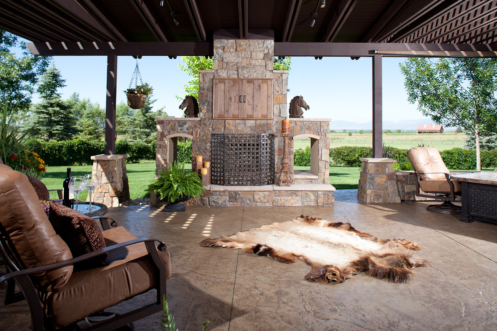 This is an example of a classic patio in Denver with a fire feature and a pergola.