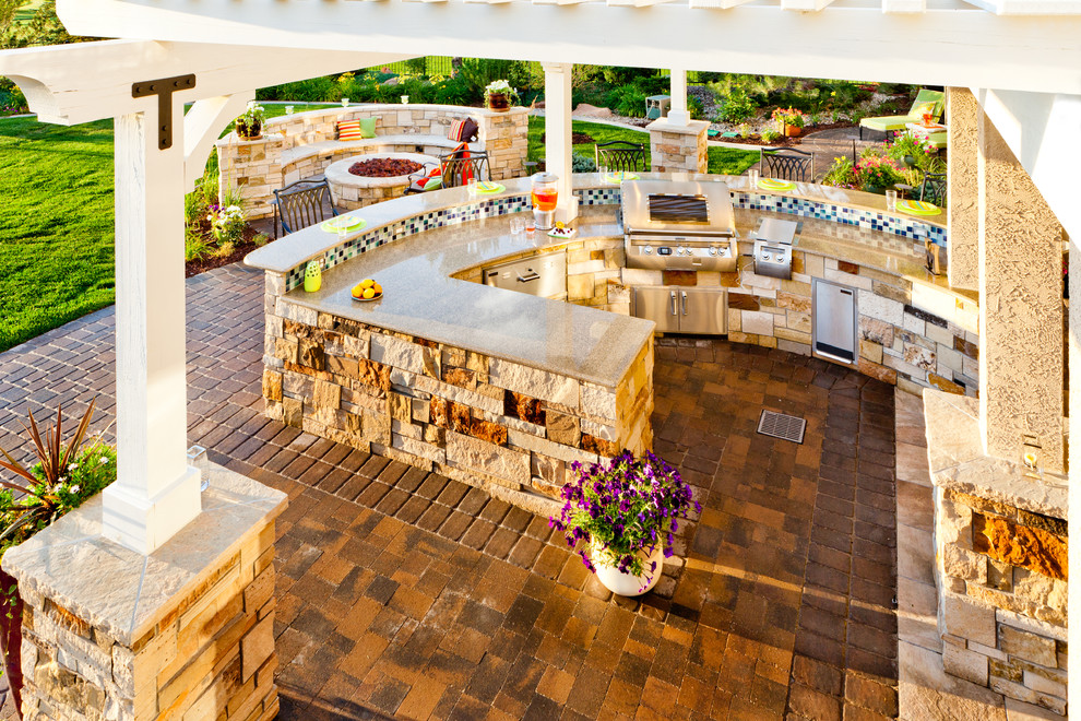 Inspiration for a large contemporary backyard concrete paver patio kitchen remodel in Denver with a pergola