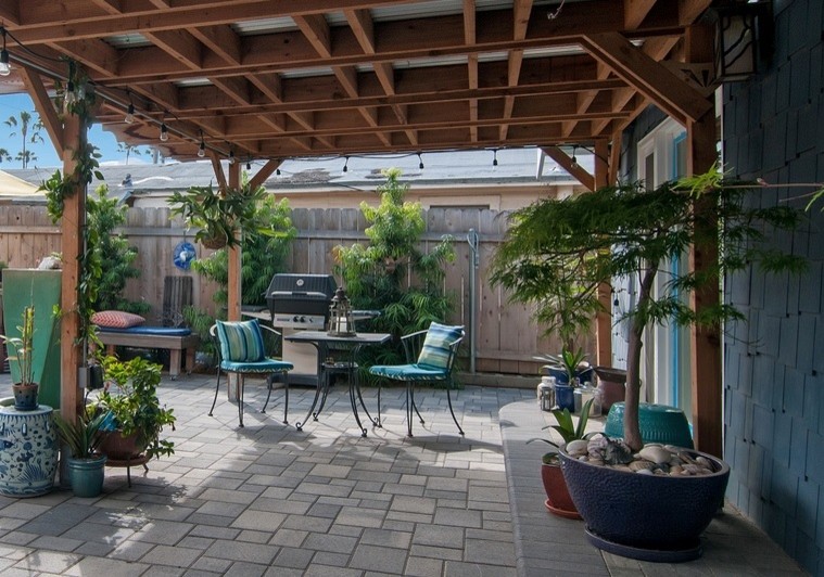 Esempio di un piccolo patio o portico stile marinaro dietro casa con un giardino in vaso, pavimentazioni in cemento e una pergola