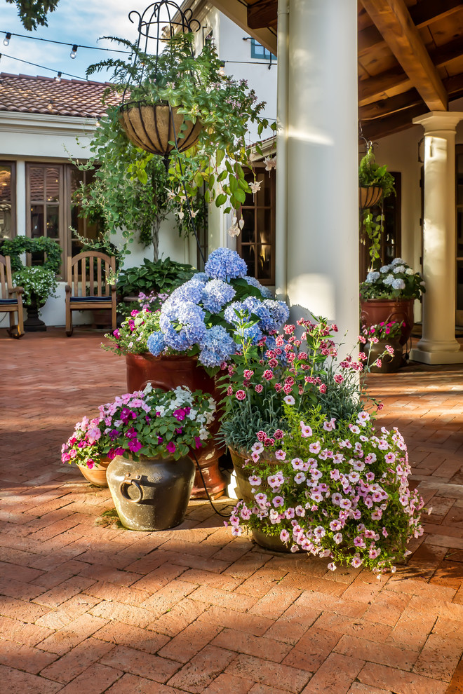 Large tuscan courtyard brick patio photo in San Francisco with a roof extension