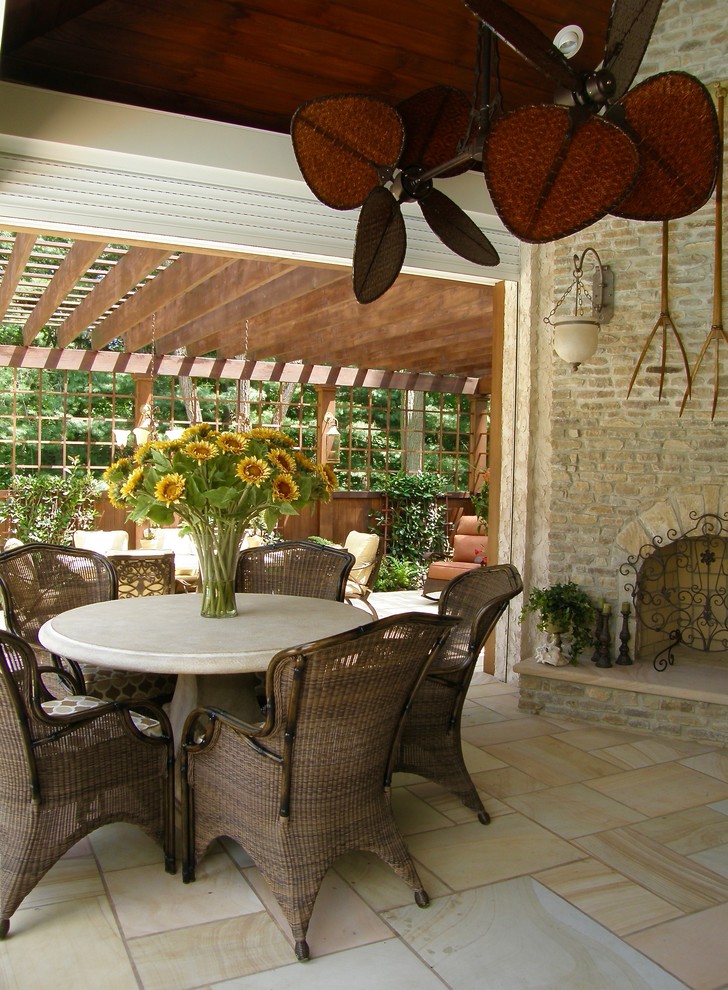 Exemple d'une très grande terrasse arrière chic avec une cuisine d'été, une extension de toiture et des pavés en pierre naturelle.
