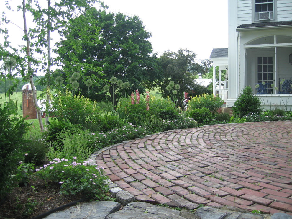 Medium sized rural back patio in DC Metro with brick paving and no cover.