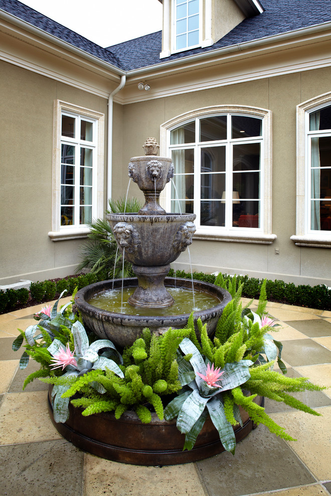 Пример оригинального дизайна: двор в классическом стиле с фонтаном и покрытием из плитки без защиты от солнца