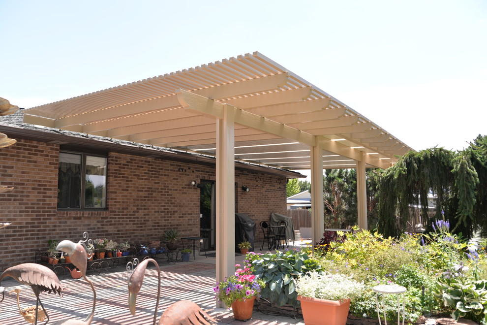 Esempio di un grande patio o portico american style dietro casa con un parasole