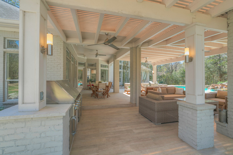Cette image montre une terrasse arrière design avec une cuisine d'été et une extension de toiture.
