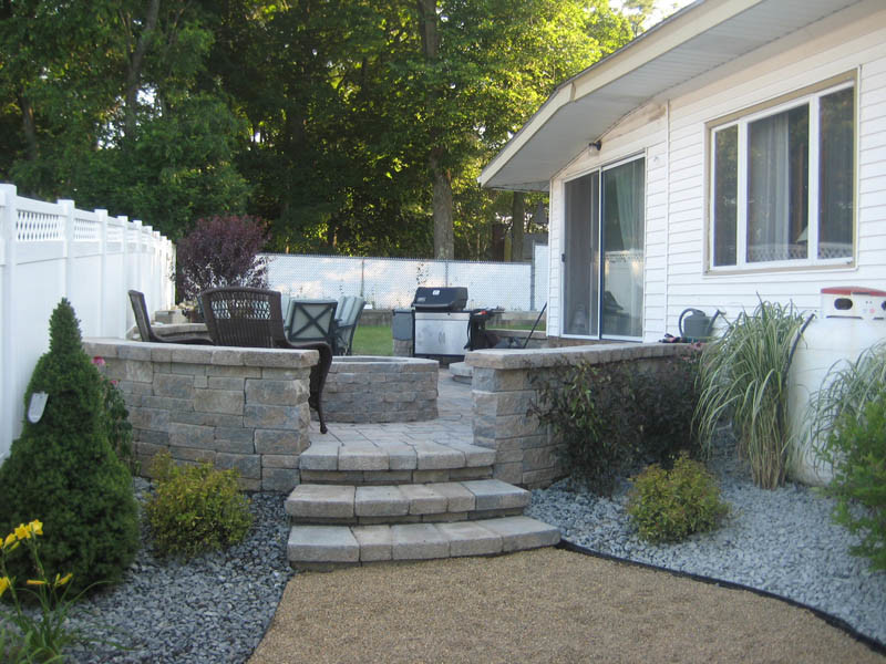 Esempio di un piccolo patio o portico moderno nel cortile laterale con un focolare e pavimentazioni in cemento