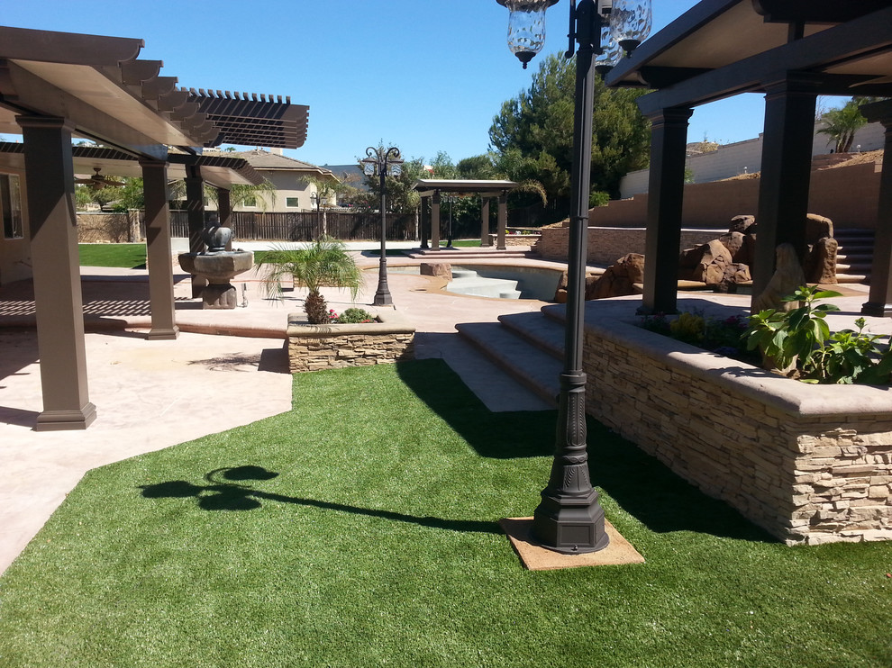 Patio - large traditional backyard stamped concrete patio idea in Los Angeles with a pergola