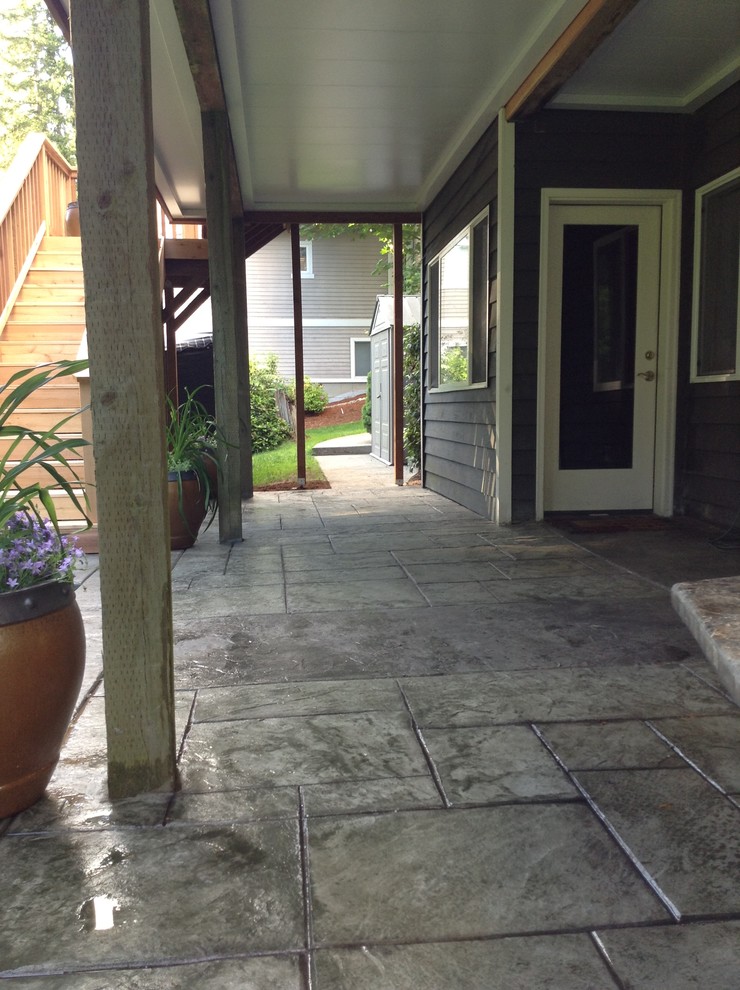 Foto di un patio o portico classico di medie dimensioni e dietro casa con un focolare e cemento stampato