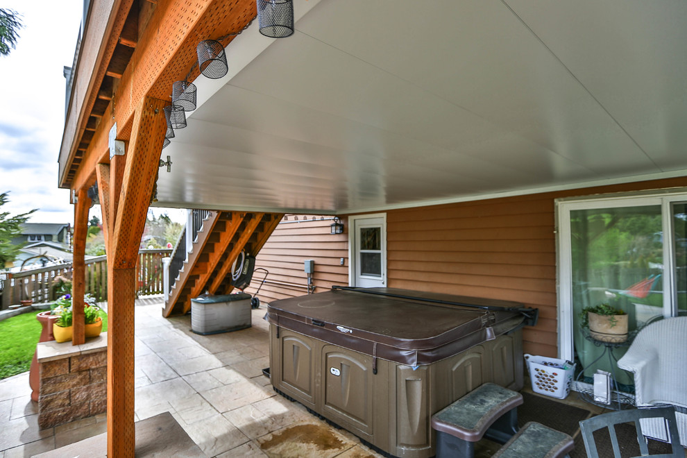Immagine di un patio o portico tradizionale di medie dimensioni e dietro casa con un focolare e cemento stampato