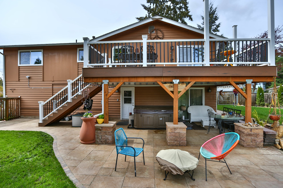 Example of a mid-sized transitional backyard stamped concrete patio design in Seattle with a fire pit