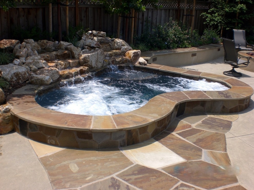 Idee per una piscina stile marinaro di medie dimensioni e dietro casa con fontane e pavimentazioni in pietra naturale