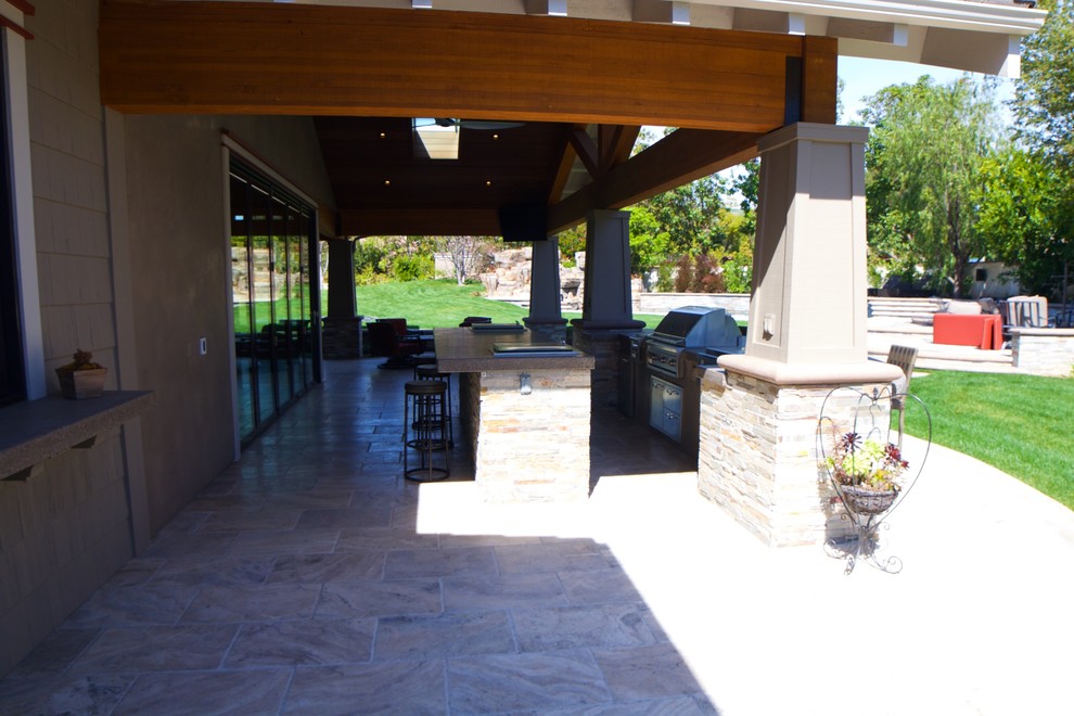 Esempio di un grande patio o portico stile americano dietro casa con piastrelle e un tetto a sbalzo