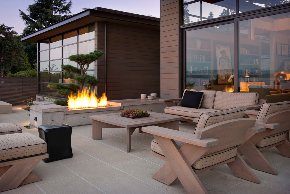 Пример оригинального дизайна: двор в современном стиле с местом для костра без защиты от солнца