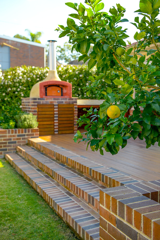 Свежая идея для дизайна: двор среднего размера на заднем дворе в современном стиле с летней кухней, настилом и навесом - отличное фото интерьера