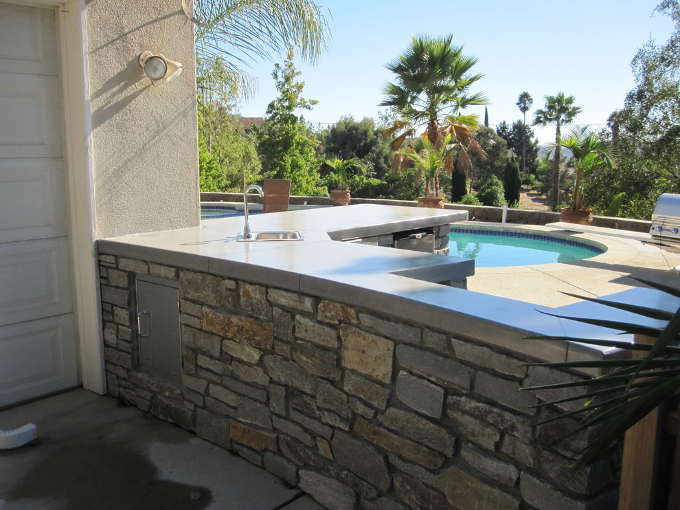 Пример оригинального дизайна: большой двор на заднем дворе в морском стиле с летней кухней и покрытием из каменной брусчатки без защиты от солнца