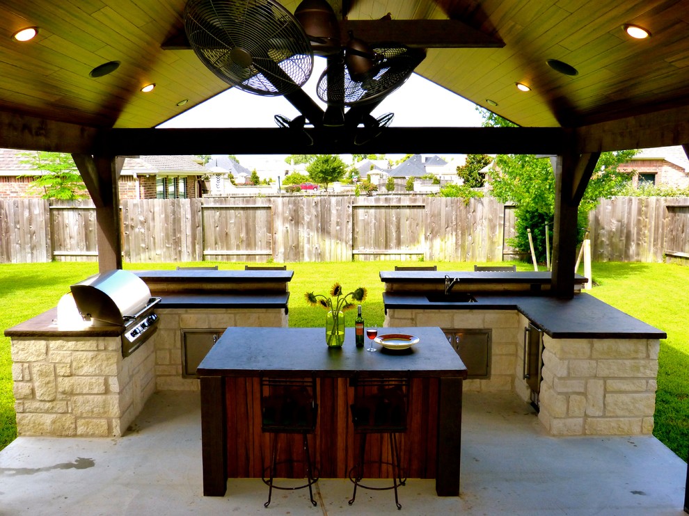 Backyard concrete patio kitchen photo in Other with a roof extension