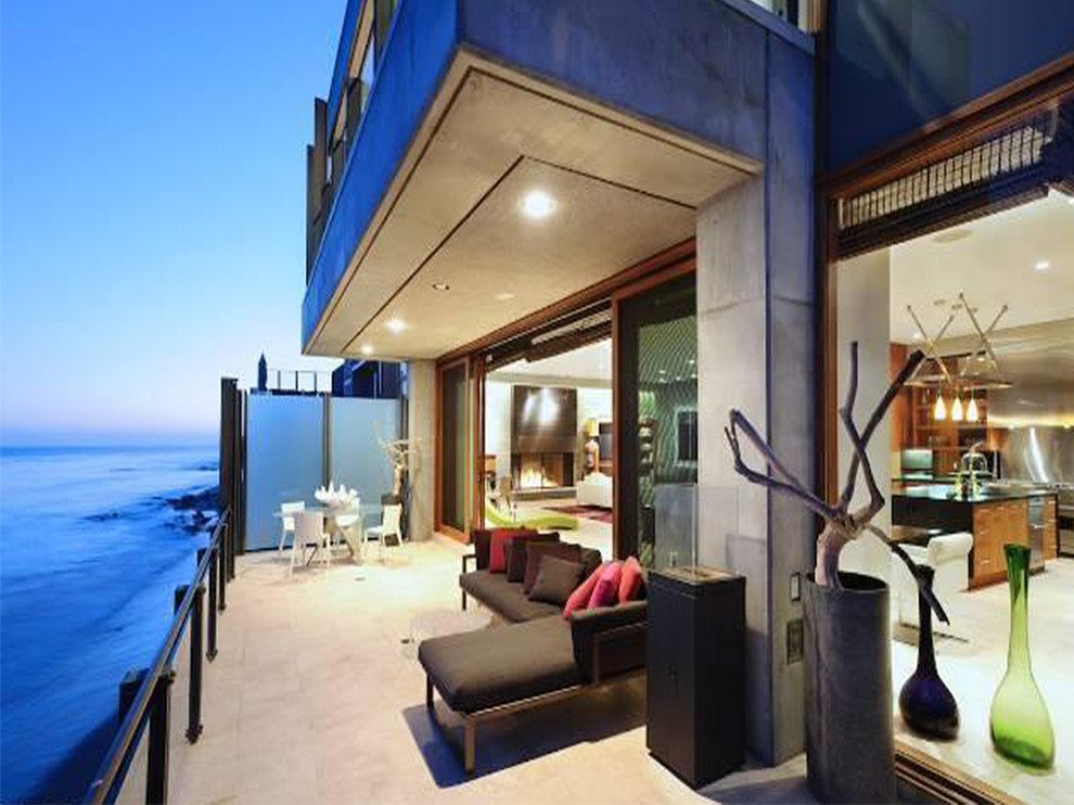 Inspiration pour une très grande terrasse arrière minimaliste avec une dalle de béton et une extension de toiture.