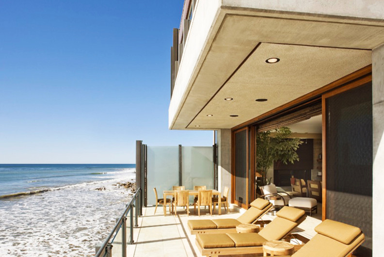 Idée de décoration pour une grande terrasse arrière minimaliste avec une dalle de béton et une extension de toiture.
