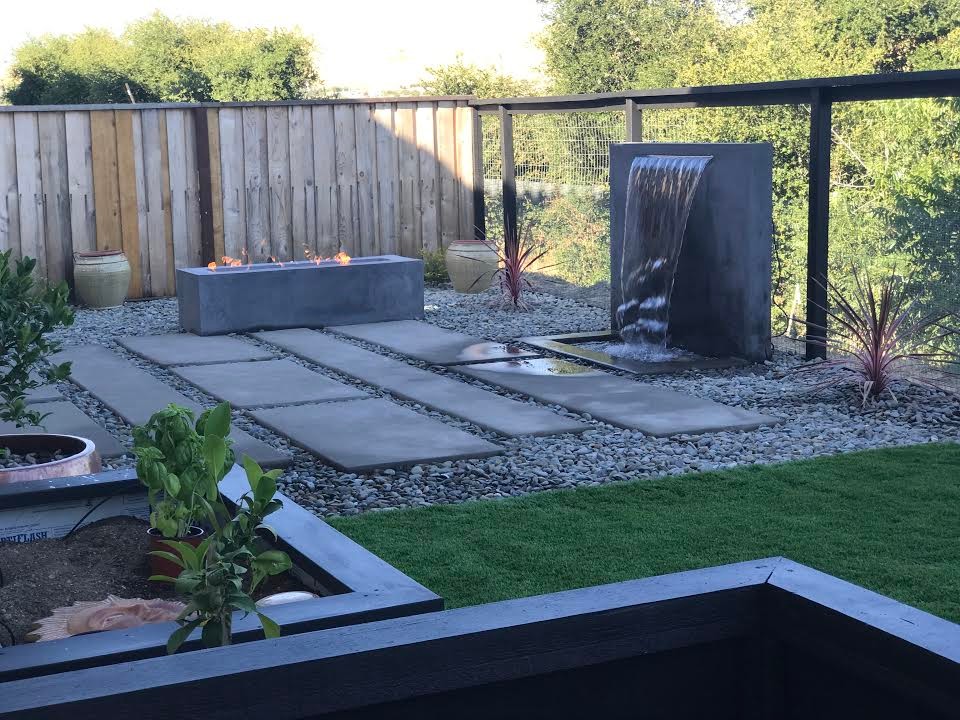 Modelo de patio contemporáneo grande sin cubierta en patio trasero con brasero y losas de hormigón
