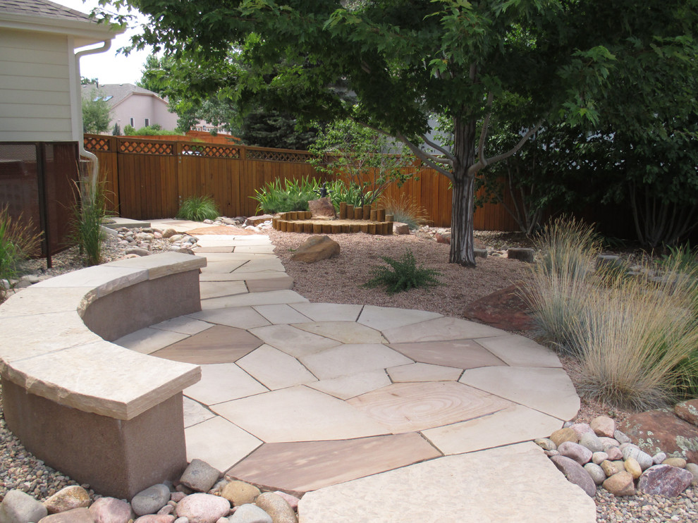 Imagen de patio contemporáneo de tamaño medio en patio trasero con brasero y adoquines de piedra natural